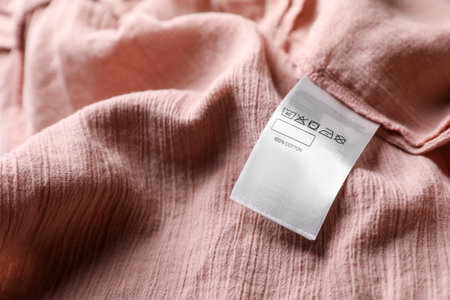 Clothing label on beautiful pink garment, closeupの写真素材