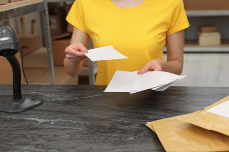 Post office worker with envelopes at counter indoors, closeupの写真素材