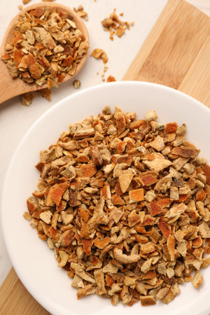 Tray with dried orange zest seasoning on wooden table, flat lay