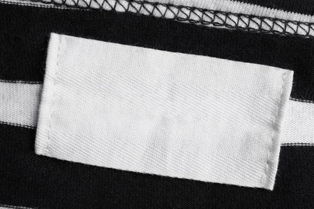 Empty clothing label on striped garment, top view