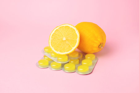 Blisters with cough drops and fresh lemons on pink backgroundの写真素材