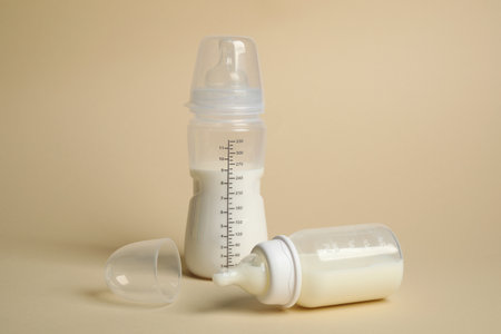 Feeding bottles with baby formula on beige backgroundの写真素材