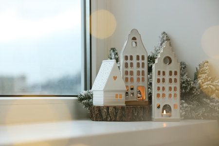 Beautiful house shaped candle holders and Christmas decor on windowsill indoors, space for text. bokeh effectの写真素材