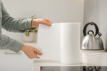 Woman tearing paper towels in kitchen, closeupの写真素材