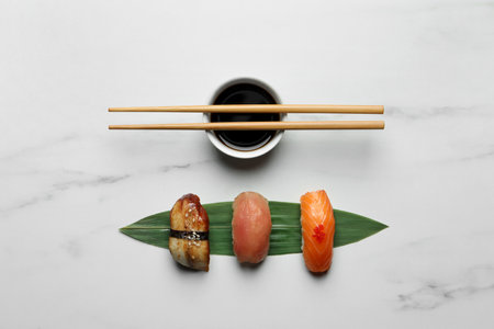 Delicious nigiri sushi, chopsticks and soy sauce on white marble table, flat layの写真素材