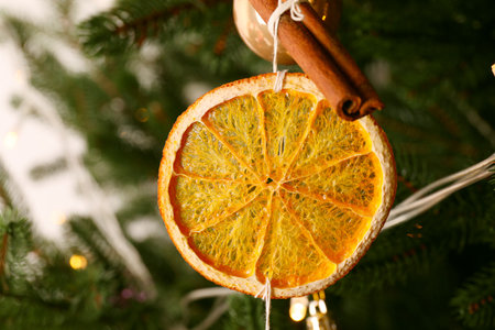 Handmade decor of dry orange slice and cinnamon stick on Christmas tree, closeupの写真素材