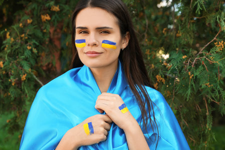 Young beautiful woman with Ukrainian flag outdoorsの写真素材