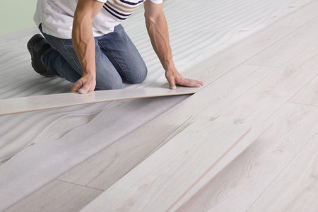 Man installing new laminate flooring indoors, closeupの写真素材