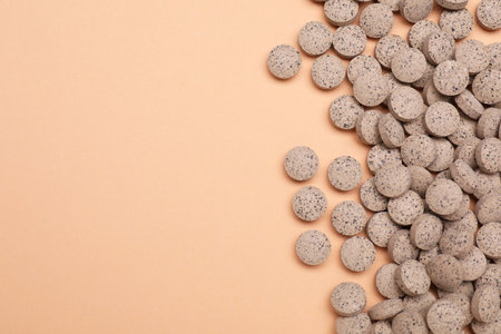 Beer yeast pills on pale orange background, flat lay. Space for textの写真素材