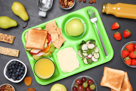 Flat lay composition with serving tray and tasty healthy food on gray table. school dinnerの写真素材