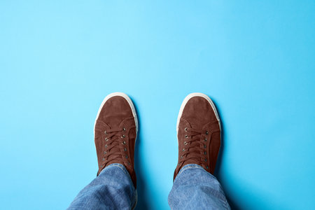Man in brown shoes standing on light blue background, top viewの写真素材