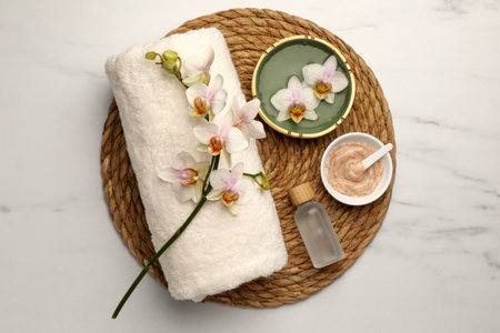 Composition with different spa products and flowers on white marble table, top viewの写真素材