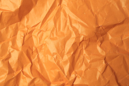 Sheet of crumpled orange paper as background, top viewの写真素材
