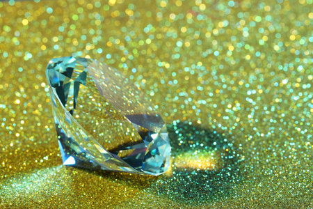 Beautiful dazzling diamond on glitter background, closeup. Space for textの写真素材