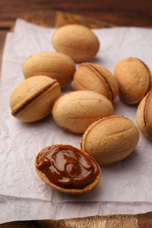 Delicious nut shaped cookies with boiled condensed milk on parchment paper, closeupの写真素材