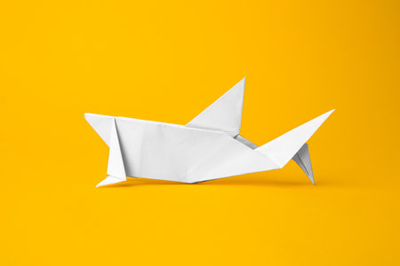 origami art. Handmade white paper shark on yellow backgroundの写真素材
