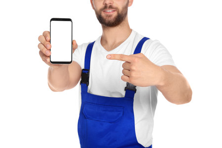 Professional repairman in uniform showing smartphone on white background, closeupの写真素材