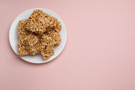 Puffed rice bars (kozinaki) on pale pink background, top view. Space for textの写真素材