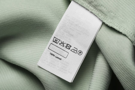 Clothing label on light green garment, top viewの写真素材