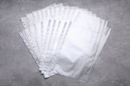 Punched pockets on gray table, flat lay