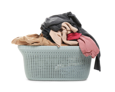 Plastic laundry basket full of clothes isolated on whiteの写真素材