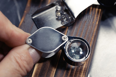 Professional jeweler working with gemstone at wooden table, closeupの写真素材
