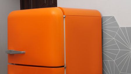 Modern closed refrigerator near colorful wall in kitchen. domestic applianceの写真素材