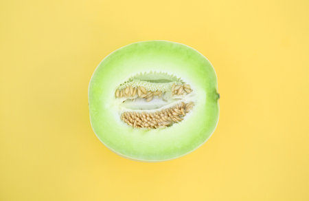 Half of fresh ripe honeydew melon on yellow background, top viewの写真素材