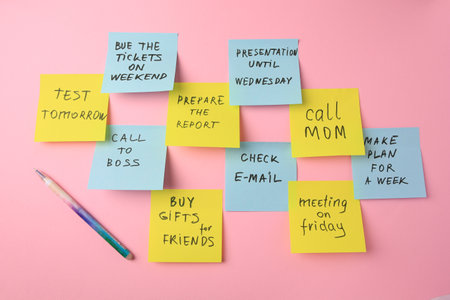 Many different reminder notes and pen on pink background, flat lay