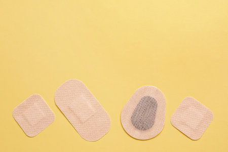 Different contraceptive patches on yellow background, flat lay. Space for textの写真素材