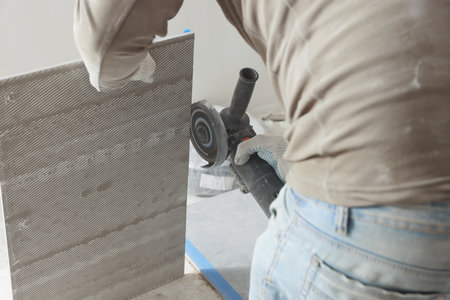 Worker cutting tile with circular saw indoors, closeupの写真素材