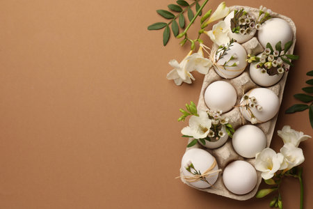 Happy Easter. Festive composition with eggs and floral decor on brown background, flat lay. Space for textの写真素材