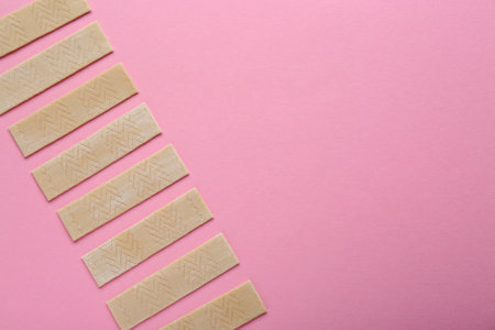 Many sticks of tasty chewing gum on pink background, flat lay. Space for text