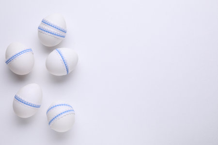 Festively decorated Easter eggs on white background, flat lay. Space for textの写真素材