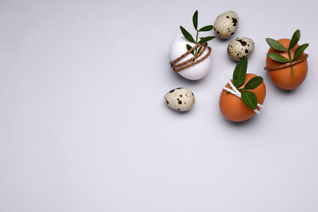 Beautifully decorated Easter eggs on light gray background, flat lay. Space for text