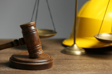 Construction and land law concepts. Gavel, scales of justice and hard hat on wooden table, closeupの写真素材