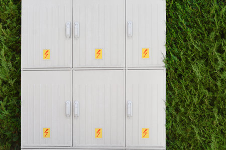 Electrical power panel near green hedge outdoorsの写真素材