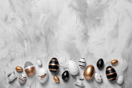Flat lay composition with festively decorated Easter eggs on textured table. Space for text