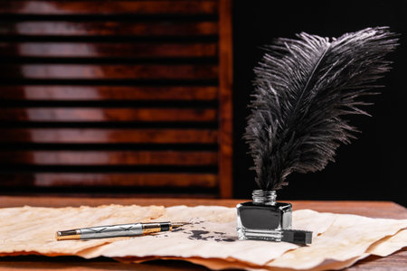 Inkwell with lush feather, fountain pen and vintage parchment with ink stains on wooden table...