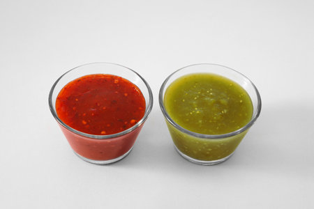 Bowls with delicious salsa sauces on white backgroundの写真素材