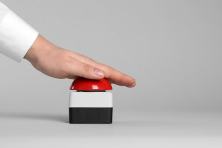 Man pressing red button of nuclear weapon on light gray background, closeup with space for text. War conceptの写真素材