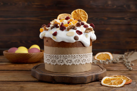 Delicious Easter cake with dried fruits and painted eggs on wooden table