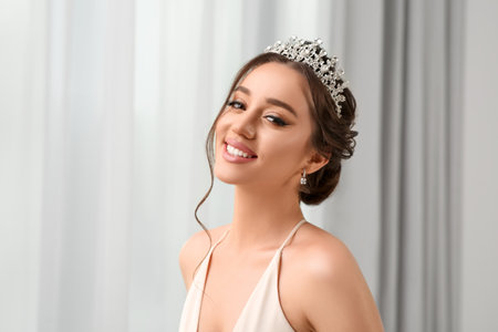 Beautiful young woman wearing luxurious tiara indoors, space for textの写真素材