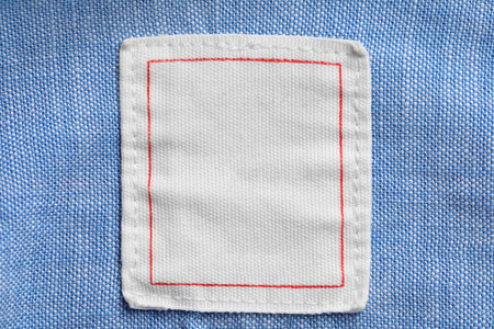Clothing label on light blue garment, top viewの写真素材