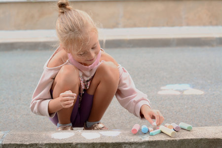 Little child drawing balloons with chalk on asphalt, space for textの写真素材