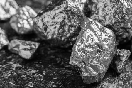 Pile of silver nuggets on gray textured table, closeup