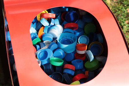 Different colorful bottle caps in red bin. plastic recyclingの写真素材