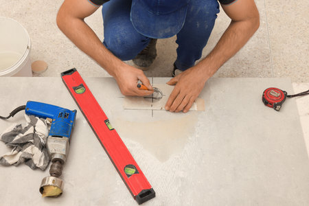 Worker making socket hole in tile indoors, closeupの写真素材