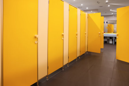 Public toilet interior with bright yellow stallsの写真素材