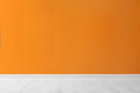 Beautiful orange wall and wooden floor in clean empty roomの写真素材
